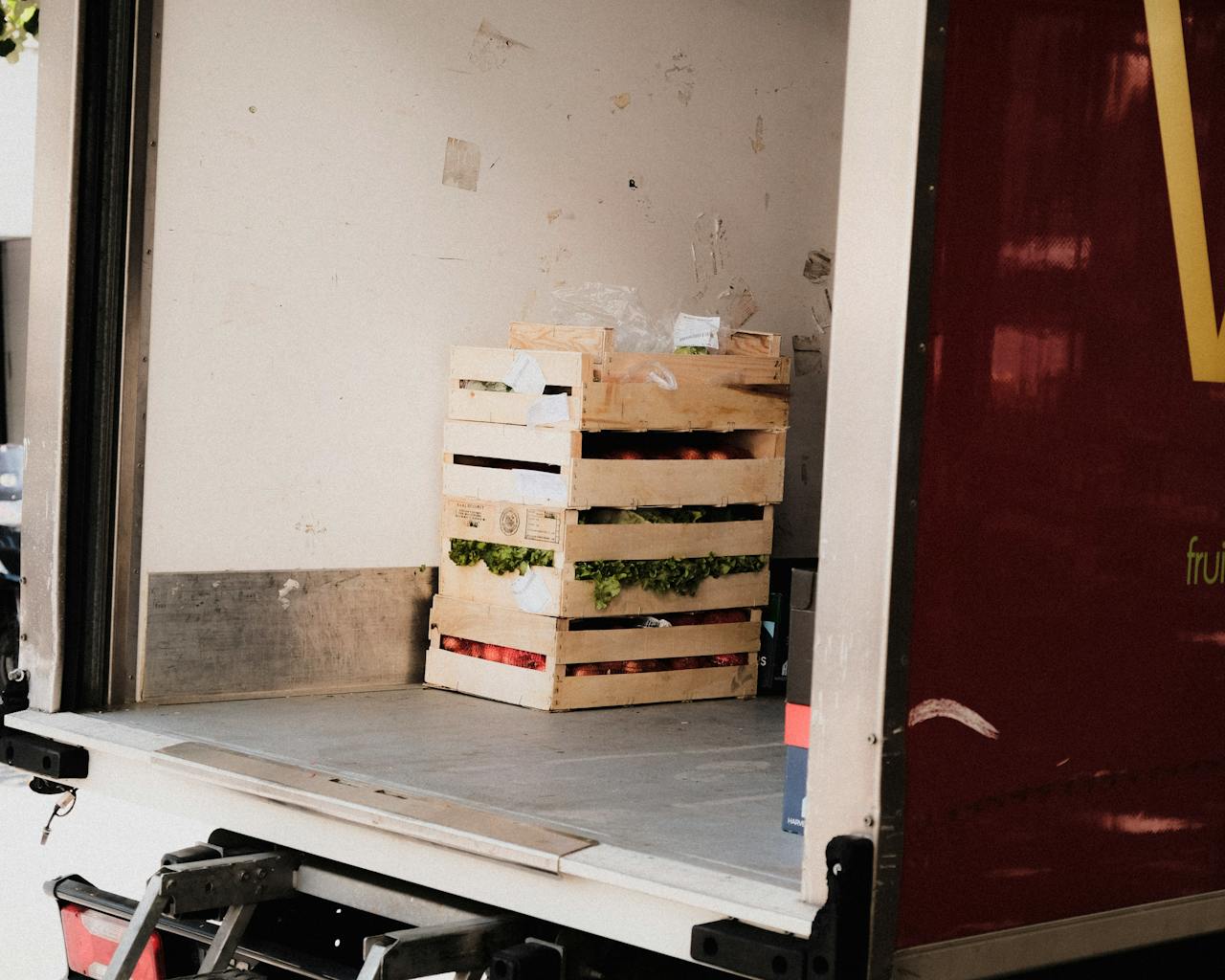 Mastering the First Impression: Your intriguing post title goes here A wooden crate with fresh vegetables loaded inside a delivery truck, ready for transportation.